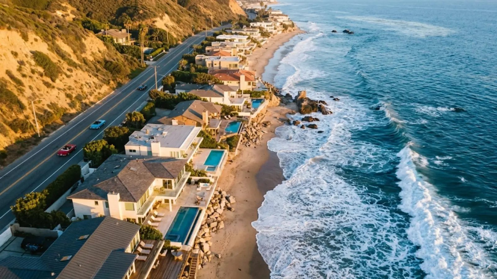 Aerial view of Malibu coastline, PCH highway, and luxury beachfront homes.